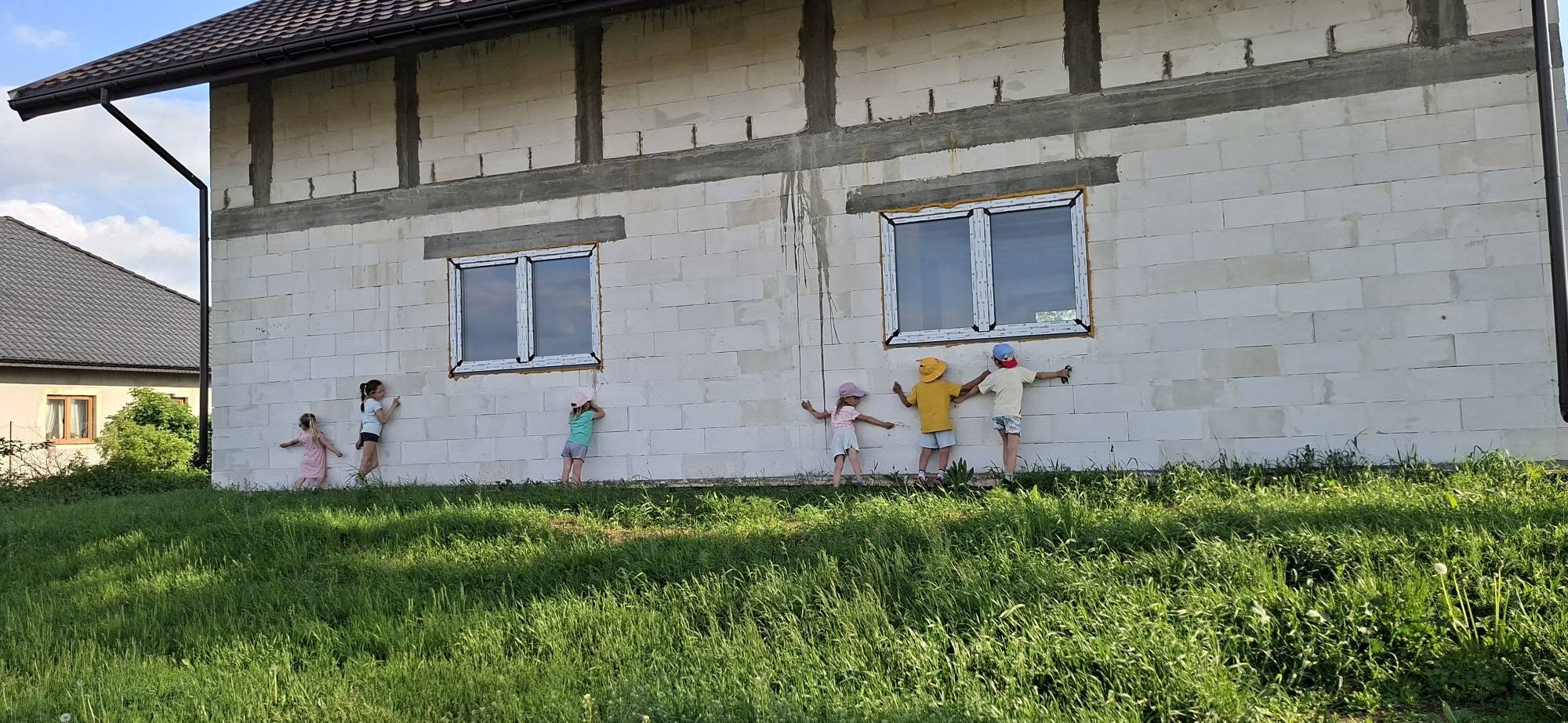 Dzieci przytulające ściany nowego domu